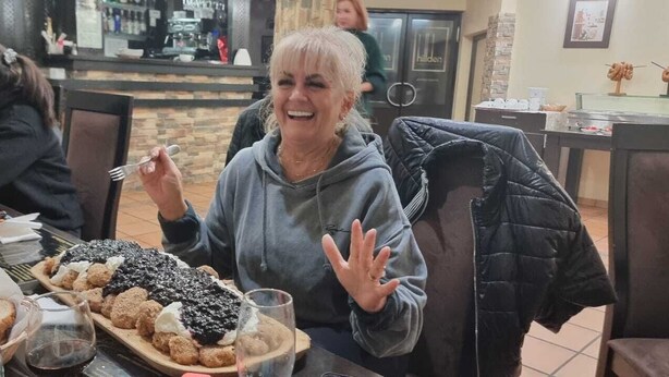 Un coin repas avec une table mise pour le repas, comprenant du pain, des pâtisseries et une bouteille.