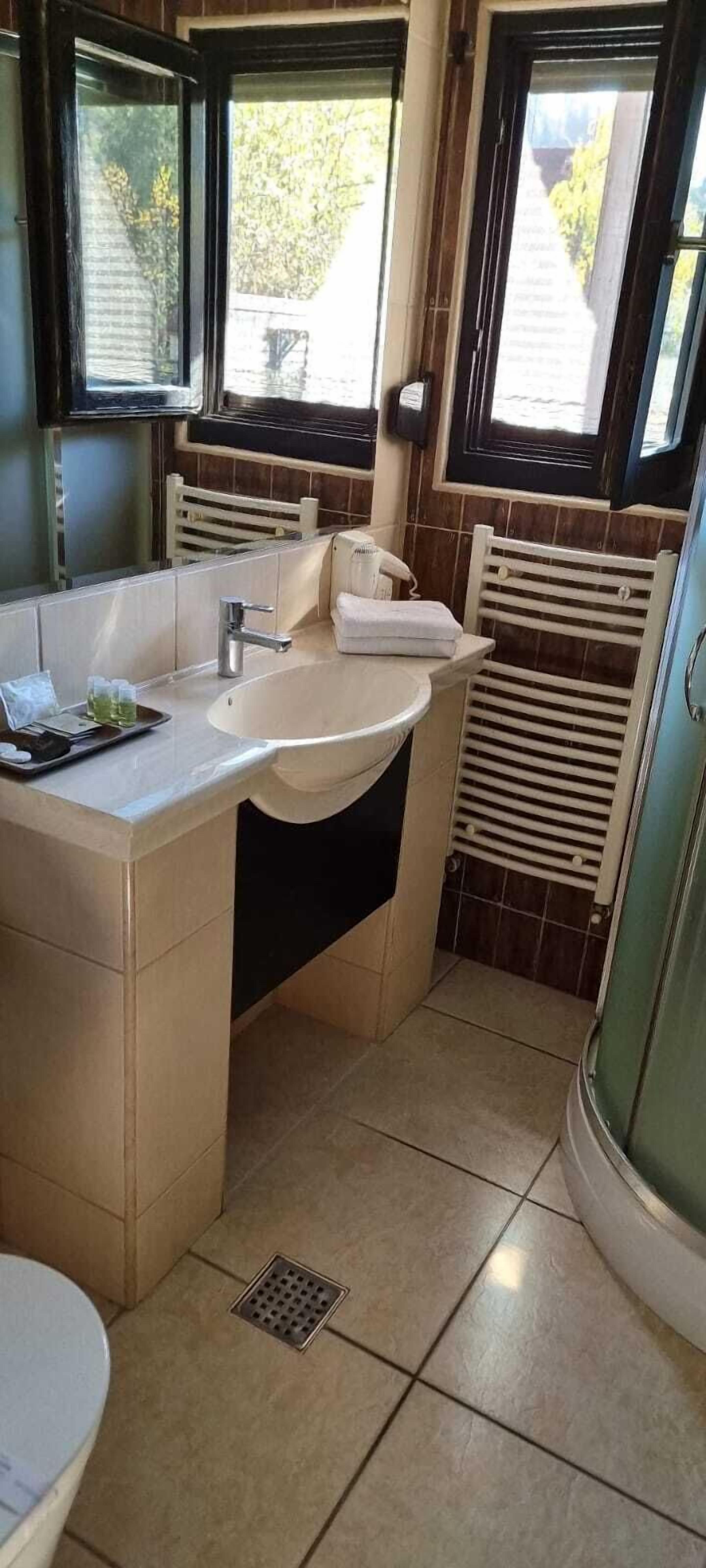 Un baño pequeño con lavamanos, espejo y retrete.