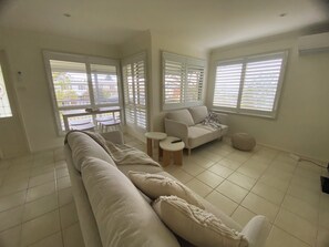 TV, books - Bungalow by the River - Water views, stones throw from River - Pet-Friendly! (Shoalhaven Heads)