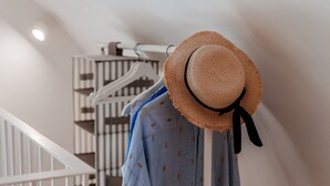 A hat and a shirt hanging on a rack in a room with a staircase. - Holiday Apartment in Puglia near the beaches (Polignano a Mare)