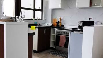 Business Apartment | Private kitchen | Fridge, microwave, cookware/dishes/utensils
