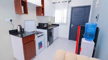 Executive Studio Suite | Private kitchen | Fridge, microwave, cookware/dishes/utensils