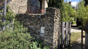 A stone building with a wooden balcony, surrounded by greenery and a wooden fence. - En Campagne un Petit Studio Douillet, Tout Équipé, à Deux pas D'azay le Rideau (Cheillé)