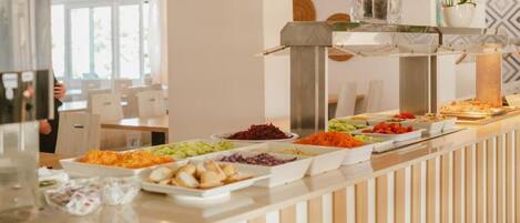 A buffet with various dishes, a modern interior with a wooden panel design, and a view of the dining area.