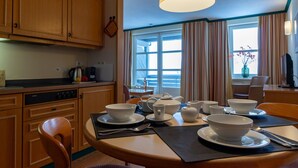 A kitchen with wooden cabinets, a Siemens dishwasher, and a dining area with a table set for four. - UplandParcs Bergresidence (Winterberg)