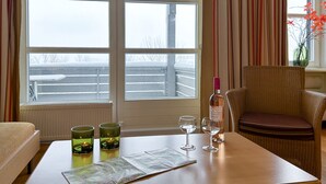 A room with a large window, a table with a map, two glasses, a bottle, and a chair. - UplandParcs Bergresidence (Winterberg)