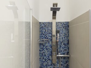 Regadera, secadora de cabello, bidet, papel de baño 