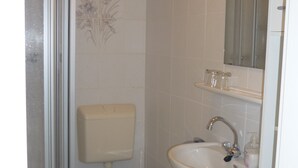A bathroom with a shower, toilet, sink, and a mirror. - Ferienwohnung an der Saline, Nr. 3 (Rheine)