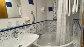 Un baño con lavamanos, bañera y cortina de ducha.