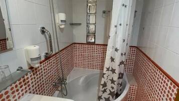 Un baño con bañera, ducha y lavamanos.