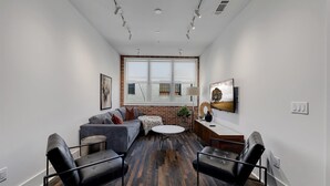 A modern living room with a sofa, chairs, a coffee table, and a fireplace. - Loft Style Spacious Lux Apt 202, sleeps 6 (Atlanta)
