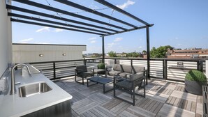 A rooftop patio with a pergola, outdoor seating, a sink, and a view of the cityscape. - Loft Style Spacious Lux Apt 203, sleeps 6 (Atlanta)