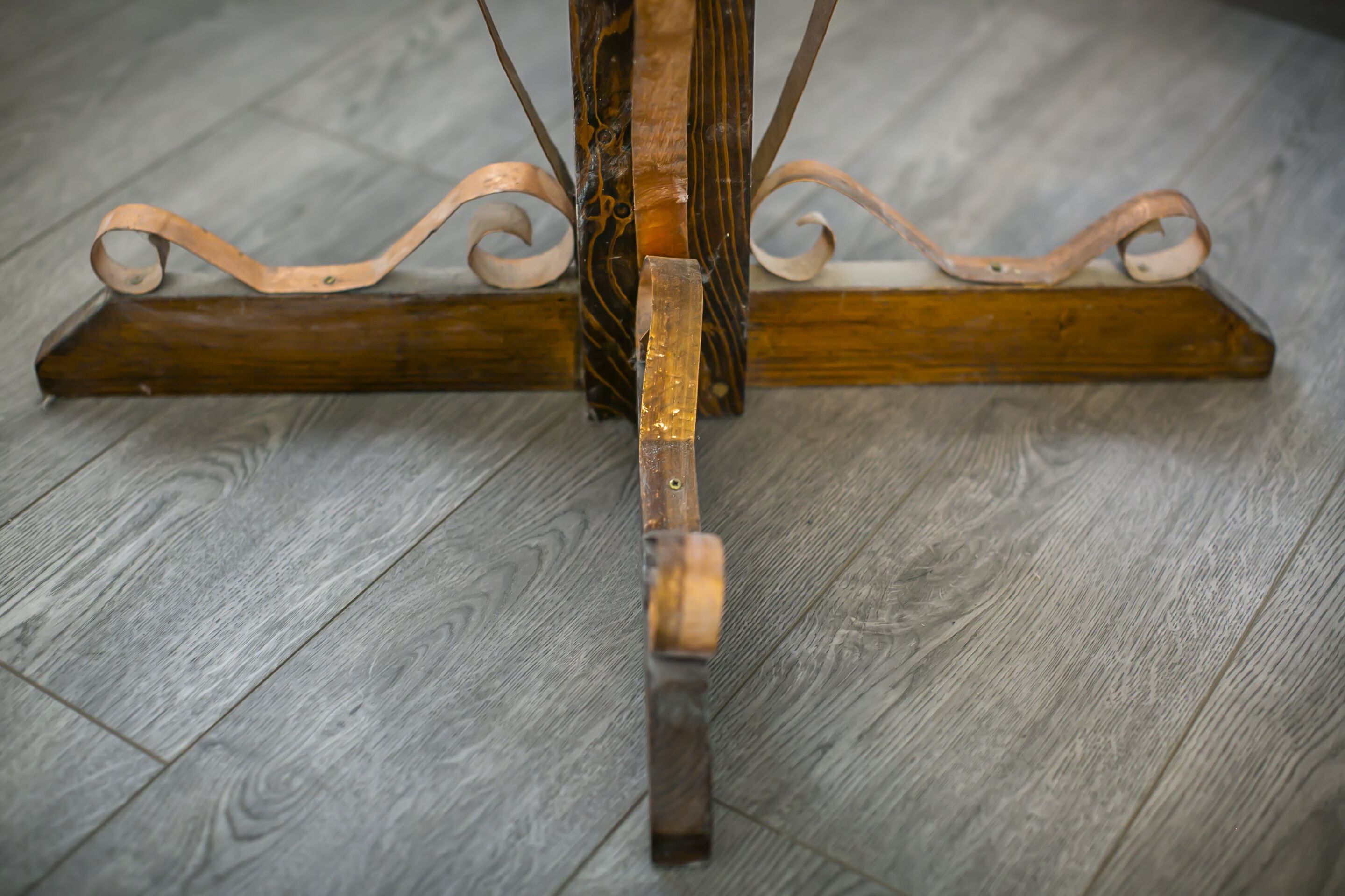 Une table en bois avec un pied en métal et un support central.