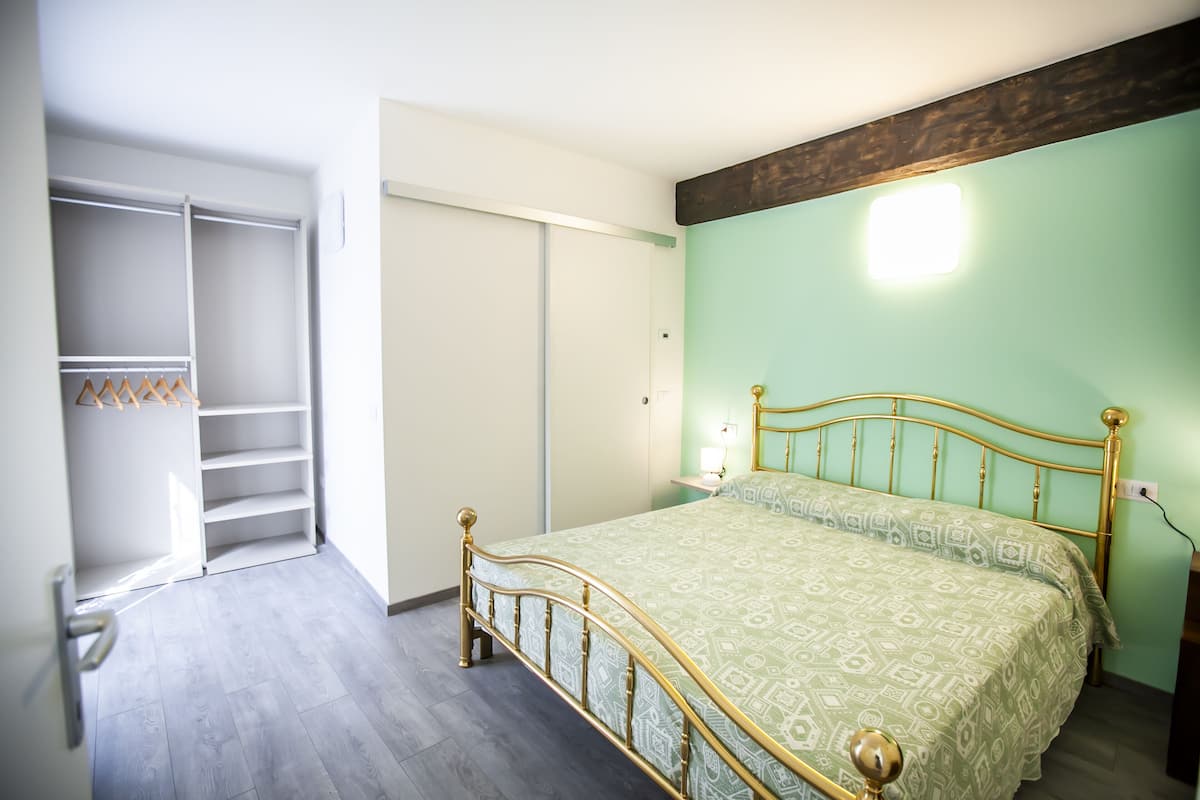 A bedroom with a bed, a wardrobe, and a nightstand.