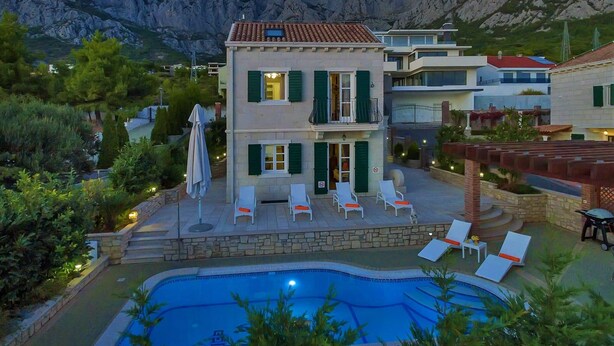 Un bâtiment à deux étages avec une piscine, entouré de montagnes.
