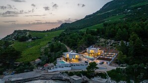 Ein Küstenanwesen mit einem modernen Haus, einem Schwimmbecken und einem Bootssteg.