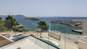 Ein Balkon mit freiem Blick auf das Meer und die entfernten Berge.