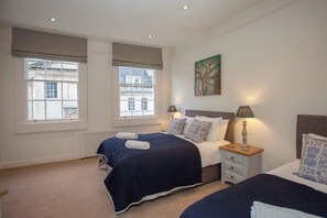 A bedroom with two beds, a radiator, and a painting on the wall. - Stunning, Bath Townhouse, City Centre (AS) (Bath)