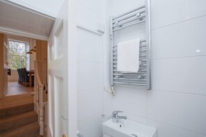 A bathroom with a white sink, a towel rack, and a shower area. - Stunning, Bath Townhouse, City Centre (AS) (Bath)