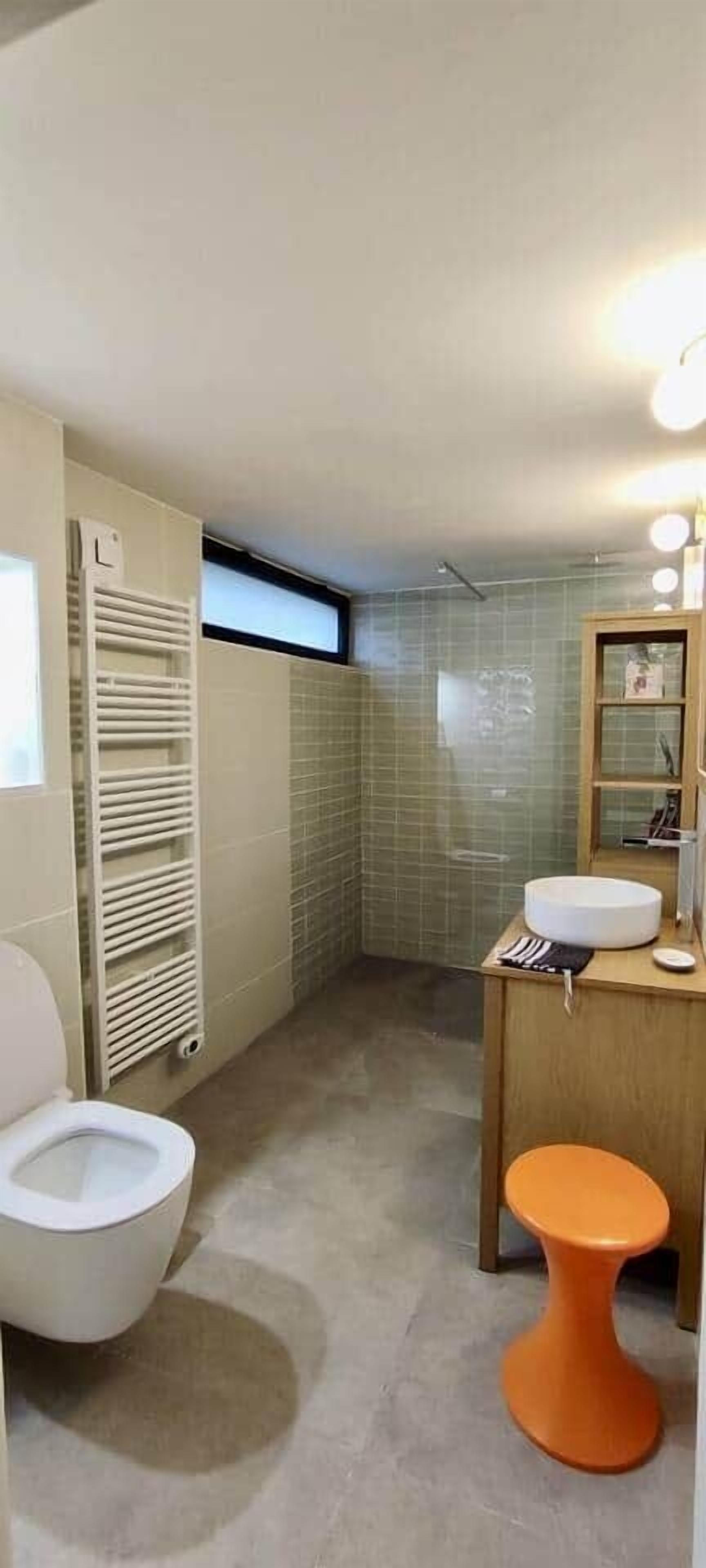 A bathroom with a toilet, sink, and mirror.