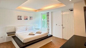 A modern bedroom with a skylight, a bed with a bench, a bedside table, and a wardrobe. - 75/2 Residence Hua Hin (Hua Hin)
