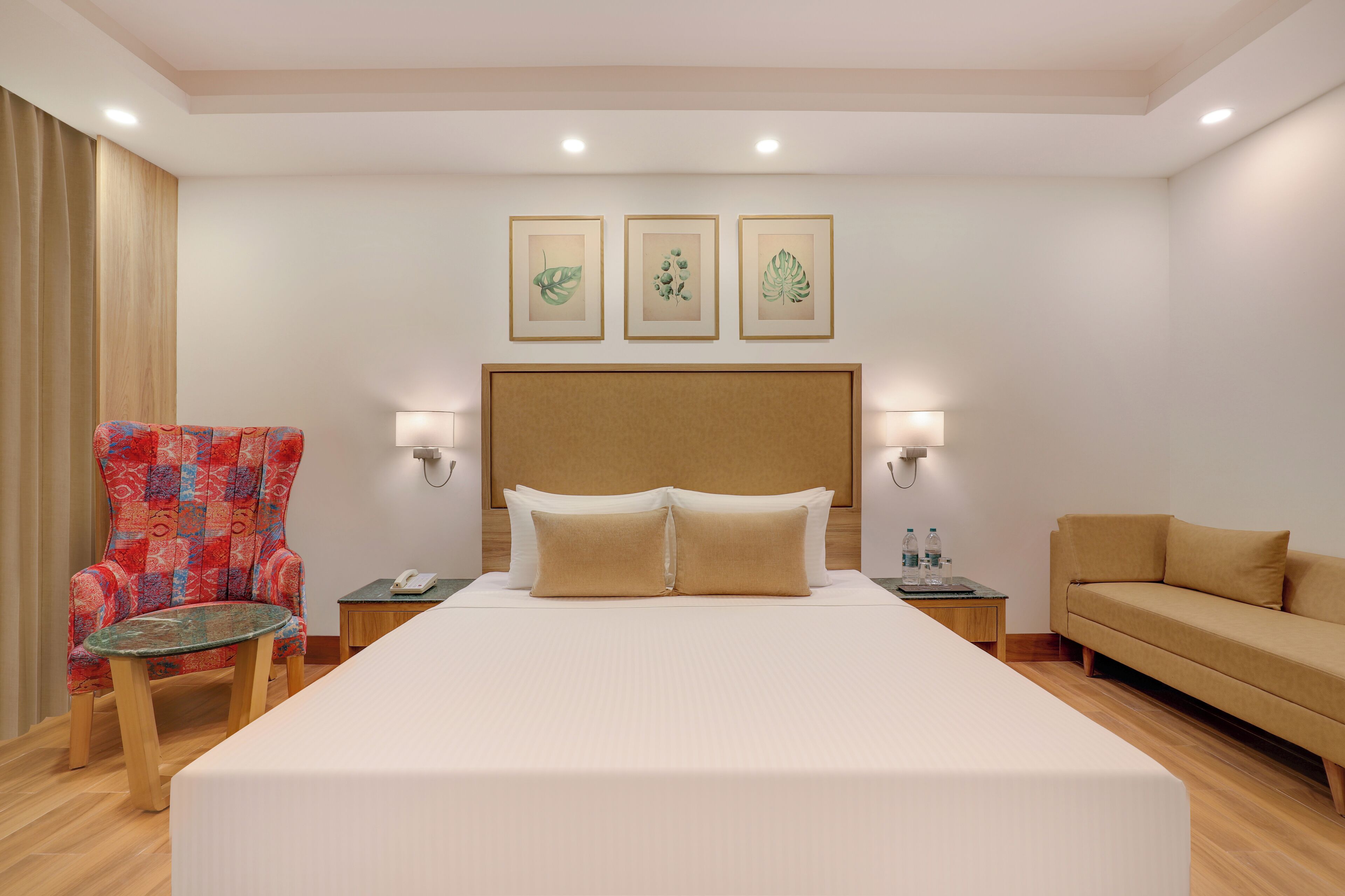 Une chambre d’hôtel avec un grand lit, une chaise, un canapé et une petite table.
