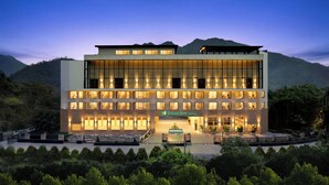 Un hotel moderno con tejado plano, varios pisos y fachada bien iluminada.