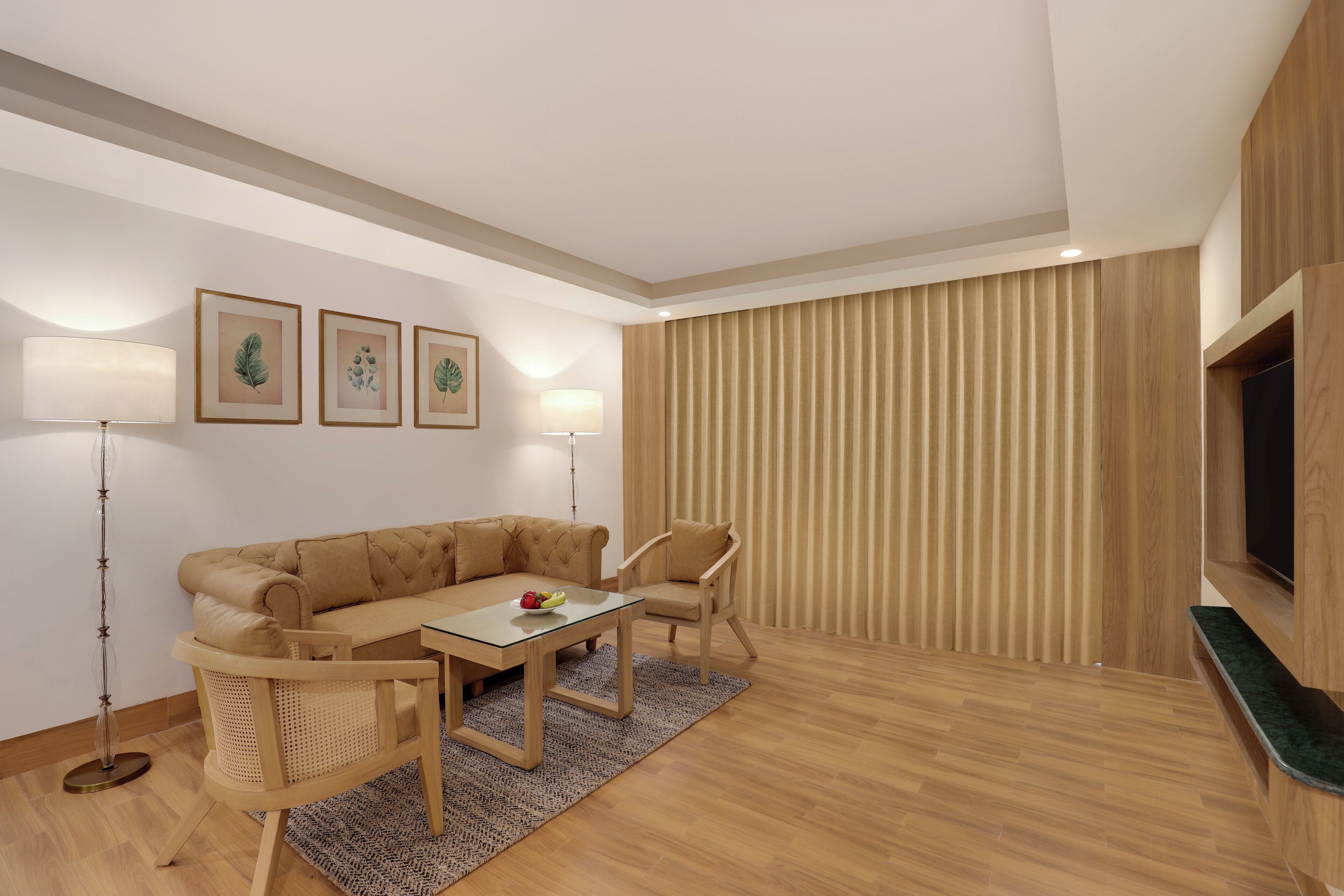 A modern living room with a sofa, chairs, a coffee table, and a flat-screen TV.