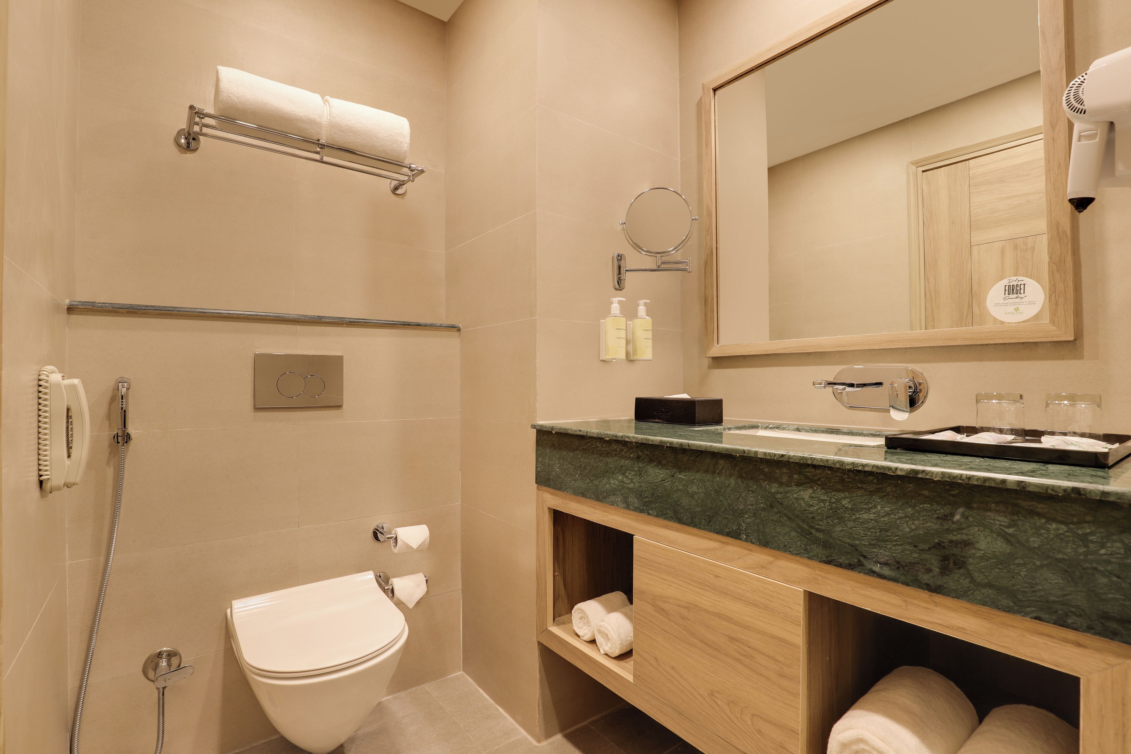 Un baño moderno con inodoro, lavamanos y toallero.