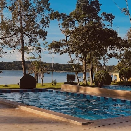 Una piscina al aire libre, sillones reclinables de piscina