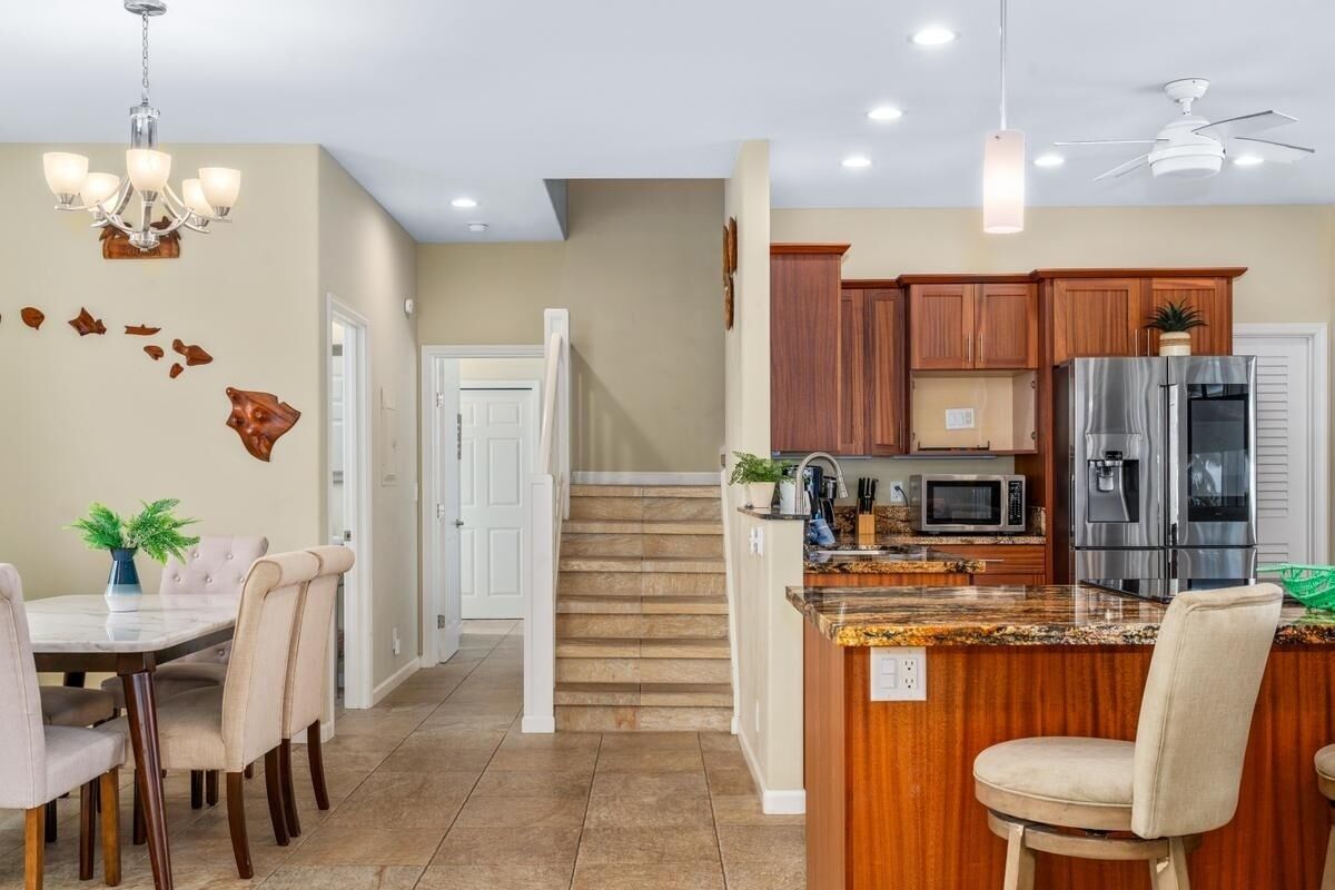 A modern kitchen with wooden cabinets, stainless steel appliances, and a granite countertop.