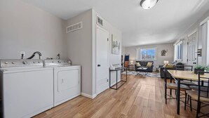 Een moderne keuken met inbouwapparatuur, een zithoek met tafel en stoelen, en uitzicht op de omgeving.