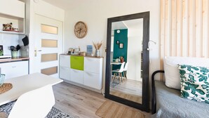 Een moderne keuken met witte kastjes, een houten aanrecht en een eethoek met een witte tafel en stoelen.