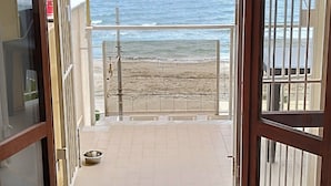 Eine offene Tür, die auf einen Balkon mit Meerblick führt.