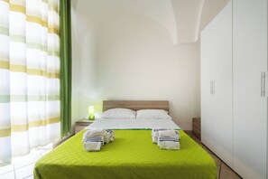 A hotel room with a bed, a nightstand, a lamp, and a wardrobe. - Isba Da Procida - Two Bedroom Apartment, Sleeps 5 (Procida)