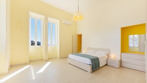 A modern bedroom with a bed, bedside tables, a wardrobe, and a window. - La Casa di Renata - Two Bedroom Apartment, Sleeps 5 (Procida)