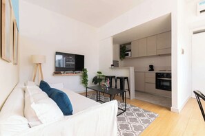 A modern apartment with a living room, dining area, and kitchen.