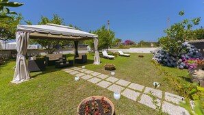 A patio area with a covered seating area, outdoor furniture, and potted plants. - Pilòn 26 - Two Bedroom Apartment, Sleeps 5 (Procida)