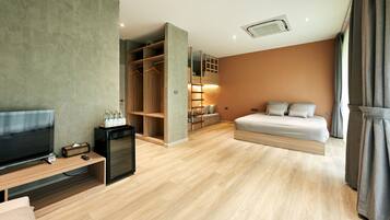 Une chambre d’hôtel moderne équipée d’un lit, d’une télévision et d’un dressing.