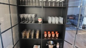 A black metal shelving unit with various glassware and containers. - Luxurious Villa in Reykjavik (Reykjavík)
