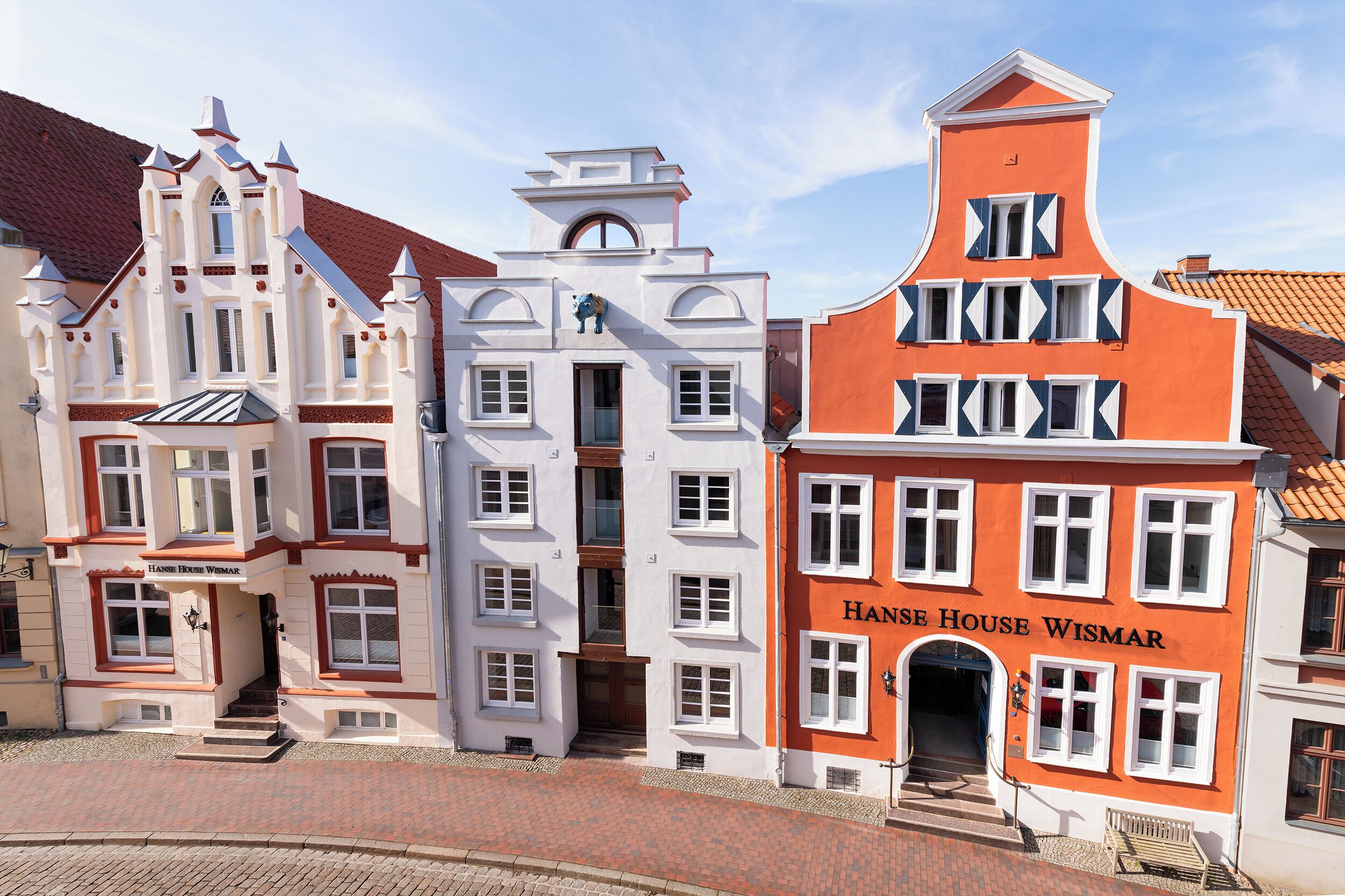Eine Reihe historischer Gebäude mit unterschiedlichen Baustilen, darunter ein Gebäude mit der Aufschrift 'Hans House Wismar'.