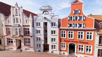 Une rangée de bâtiments historiques aux styles architecturaux distincts, dont l’un est identifié par l’inscription « Hans House Wismar ».