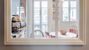 A kitchen with cabinets, a sink, and a dining area with a table and chairs.