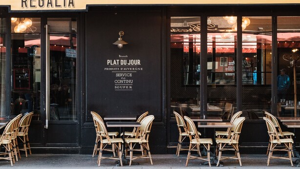 Un restaurante llamado 'Regalia' con terraza y un cartel que indica que sirve desayuno, almuerzo, cena, ofrece servicio y sopa.