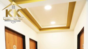 A hallway with three wooden doors, each marked with a number. The floor is tiled with a marble pattern. - K K Luxurious Home Stay (Garudeshwar)