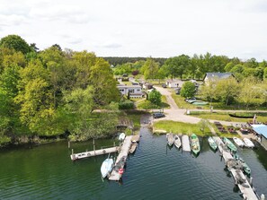 Enjoy serene lakeside views and relax on the dock with a boat moored nearby.