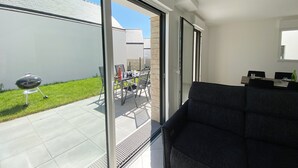 Un salon moderne doté d’une grande porte-fenêtre coulissante donnant sur un patio.