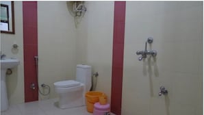 A bathroom with a toilet, sink, shower, and two buckets. - Hotel Jhansla By GRB (Behror)