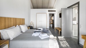 Ein modernes Schlafzimmer mit einem großen Bett, einem Holzkopfbrett, einem Nachttisch und einem Kleiderschrank.