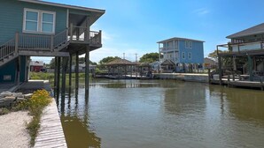 Une propriété située au bord de l’eau, avec une maison dotée d’un balcon et d’une jetée s’avançant dans l’eau.